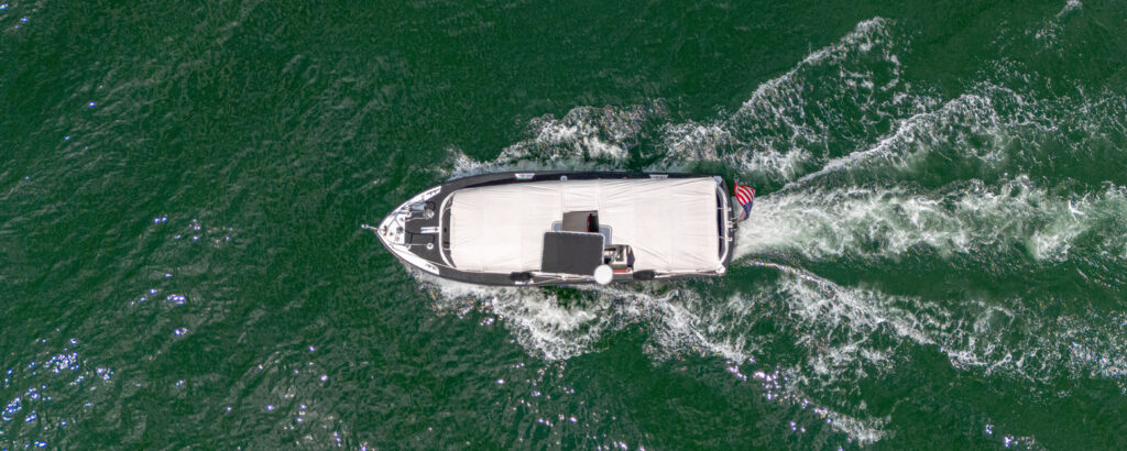 Aerial of white boat sailing in green ocean; Photo Credit: Peter G. Morneau Photography